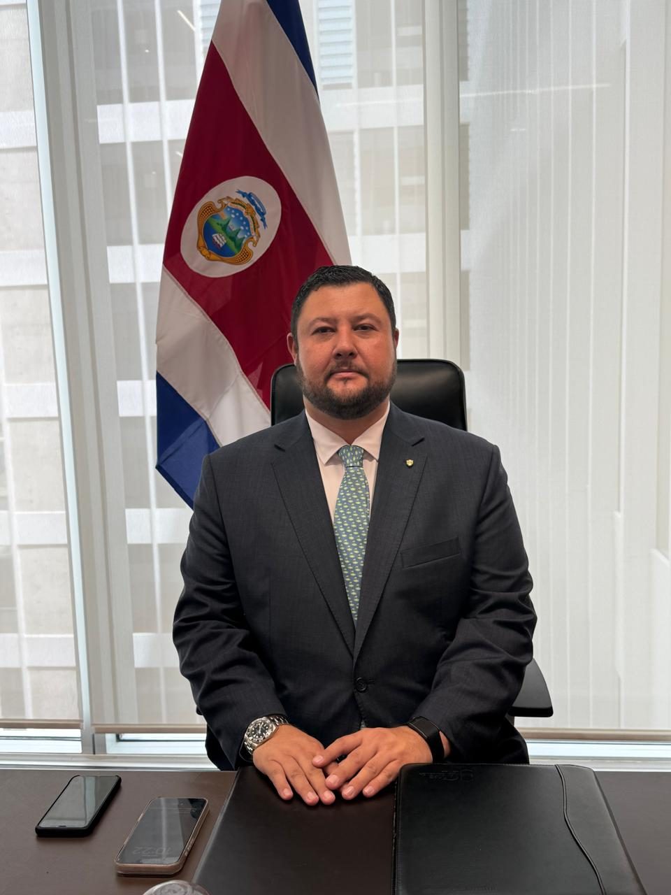 Raúl Zamora en su escritorio con la bandera de Costa Rica